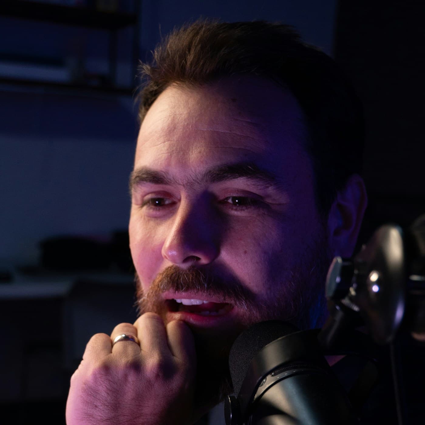 Creator focused at a microphone while planning the next upload